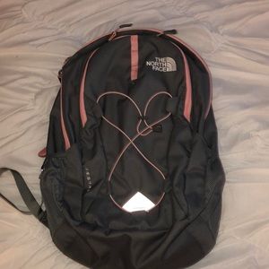 gray and pink north face book bag